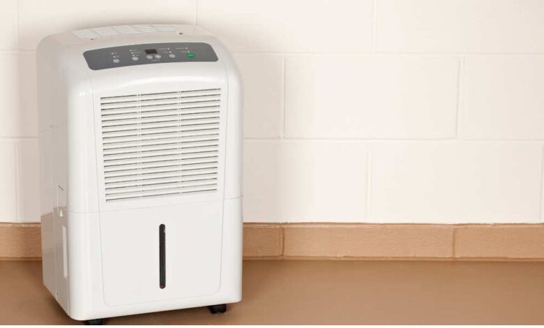 a white dehumidifiers on toscana color floor with white background wall.