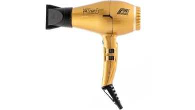 a golden and black color parlux alyon hair dryer with white background.